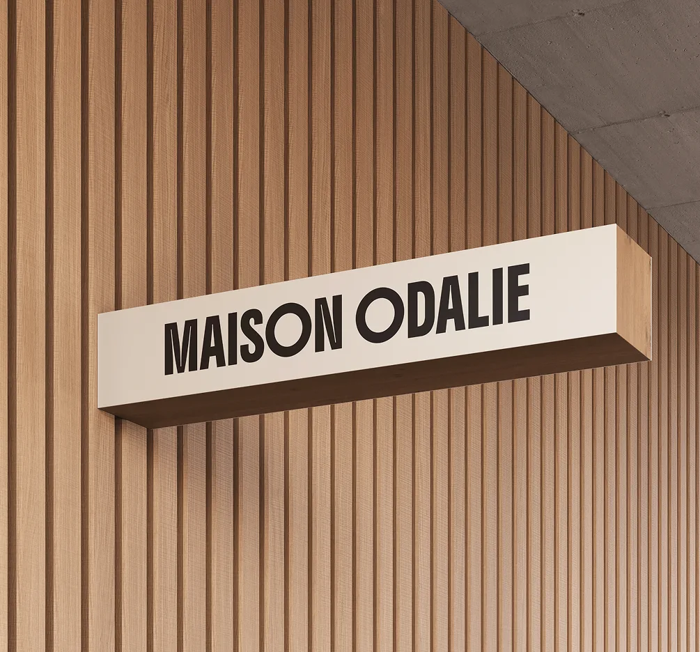 Enseigne lumineuse Maison Odalie sur un mur en bois